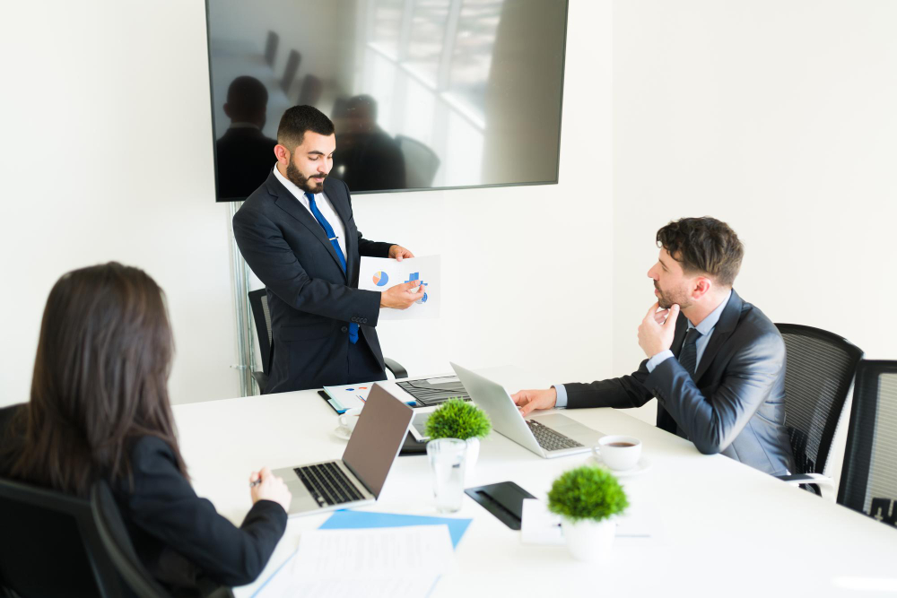 Business meeting with financial reports and laptops