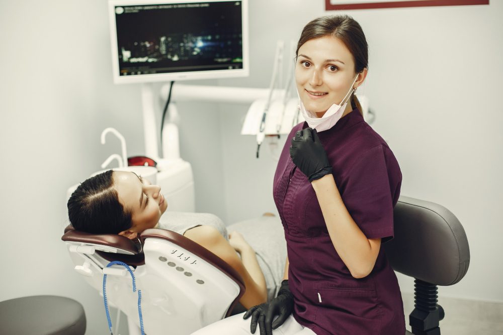 Dentist standing beside a patient in the treatment chair at a dental practice