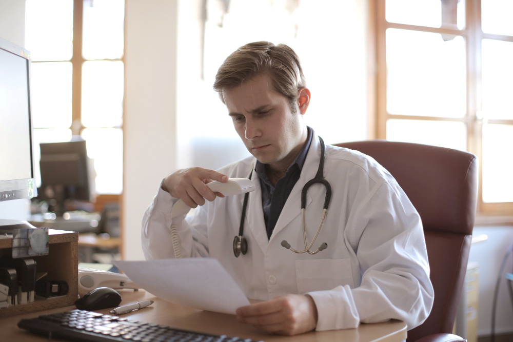 Physician practice owner reviewing a document at his office desk