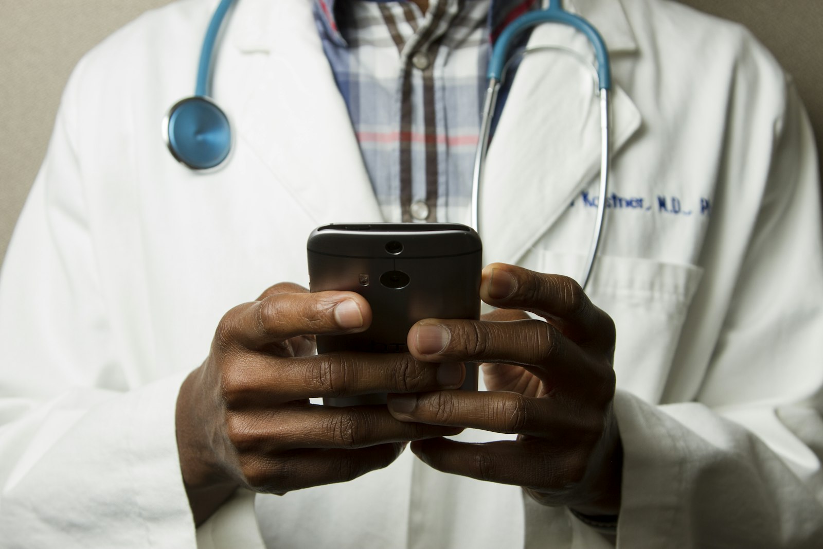 Medical professional using a mobile device with a stethoscope